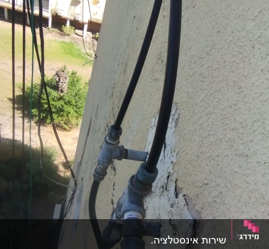 צינורות מים מחוברים לקיר חיצוני של בניין